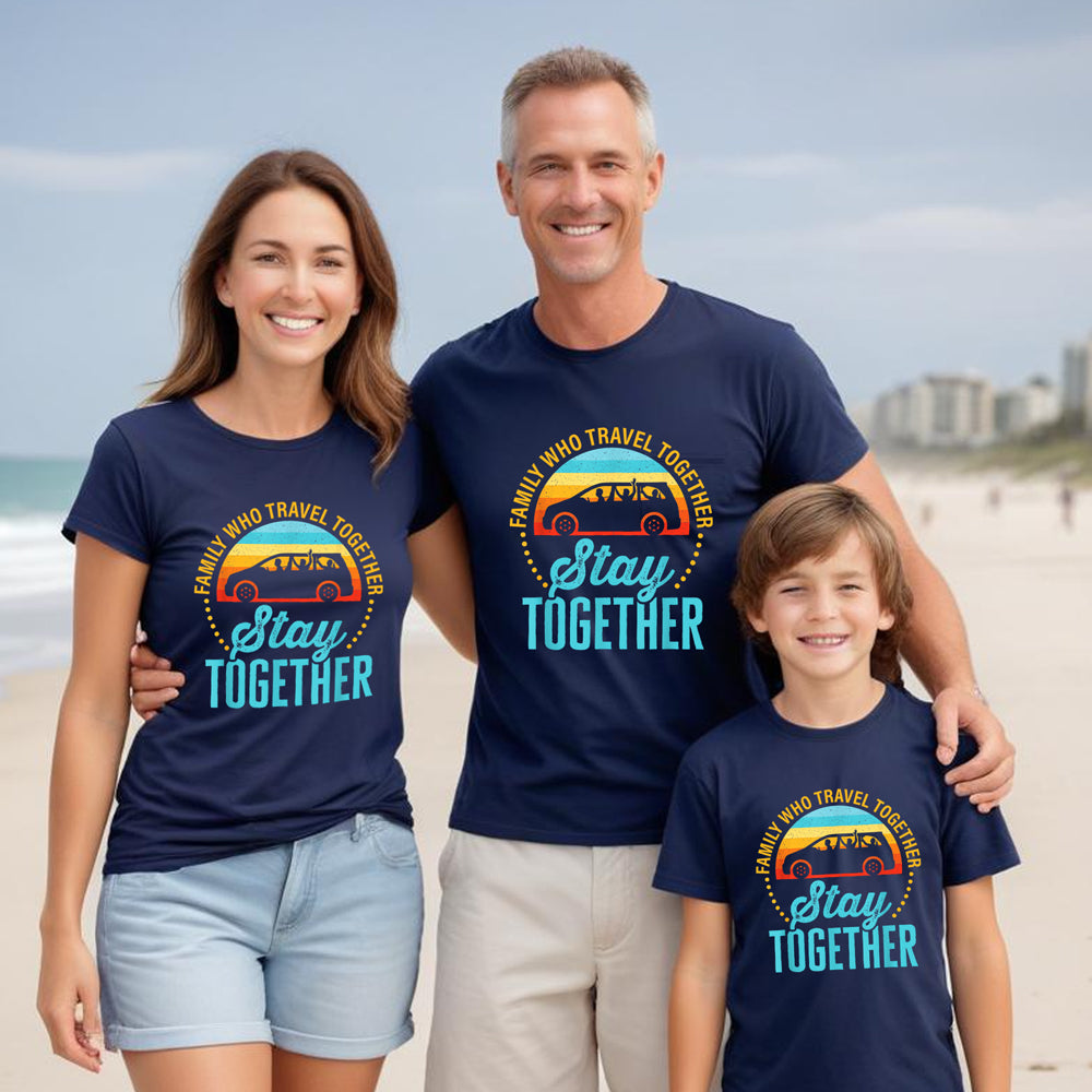 Family of three wearing matching navy blue t-shirts with a graphic design on a beach.