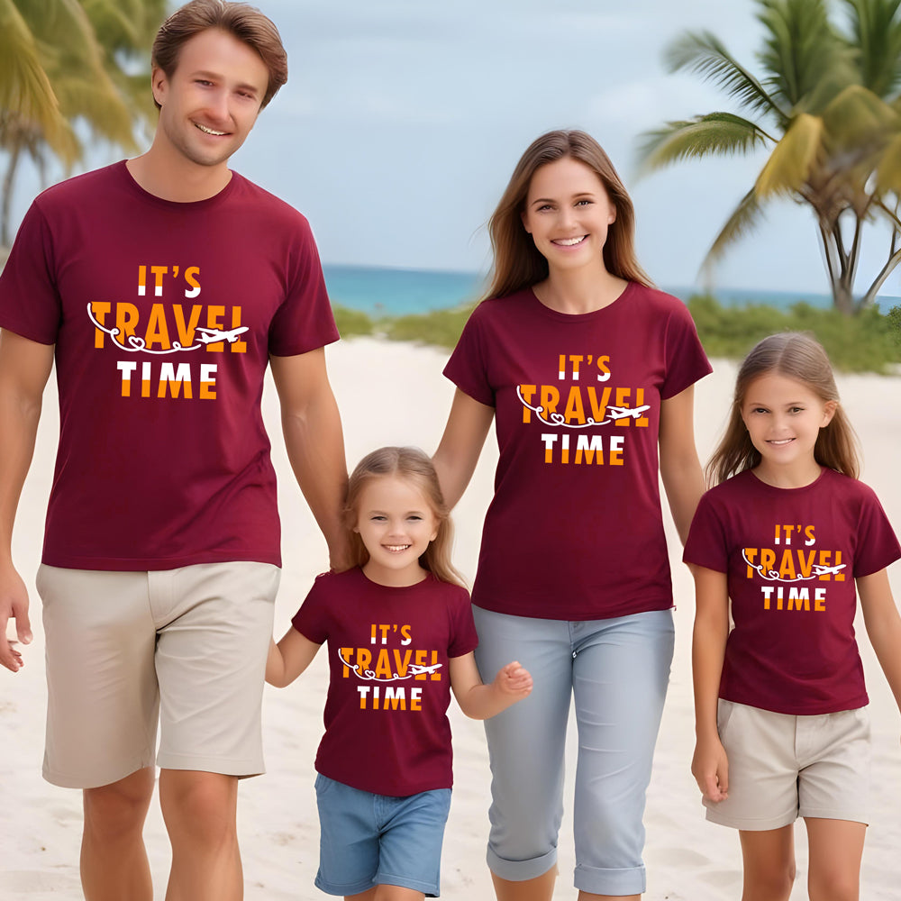 Family of four on a beach wearing matching maroon t-shirts with 'It's Travel Time' text.