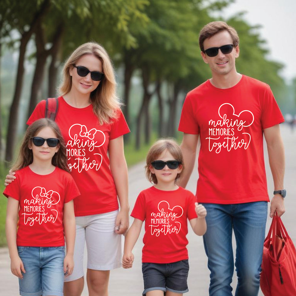 Family of four wearing matching red t-shirts with a heart design and text, standing outdoors.