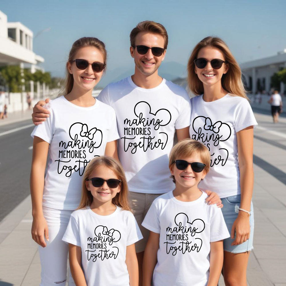 Family of five wearing matching white t-shirts with a heart design and text on a sunny street.