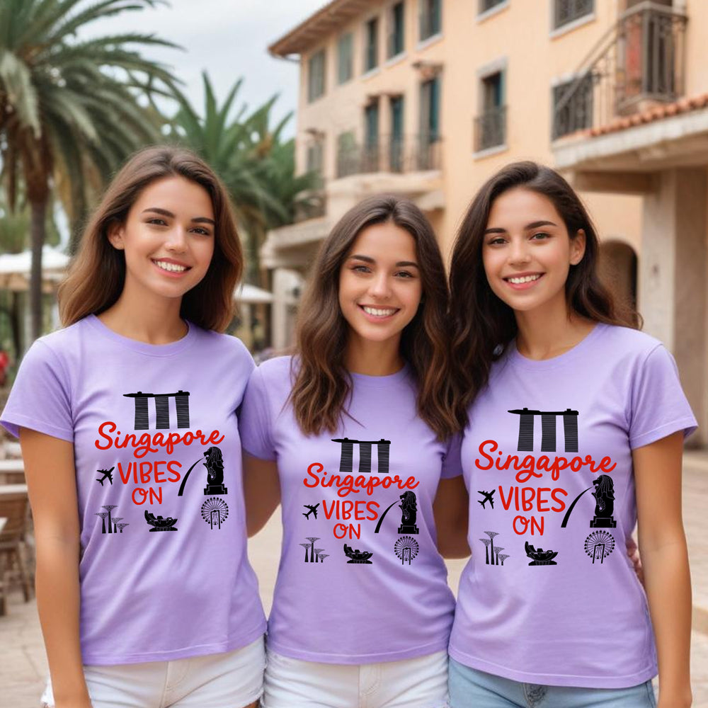 Three women wearing purple t-shirts with 'Singapore Vibes On' text and graphics.