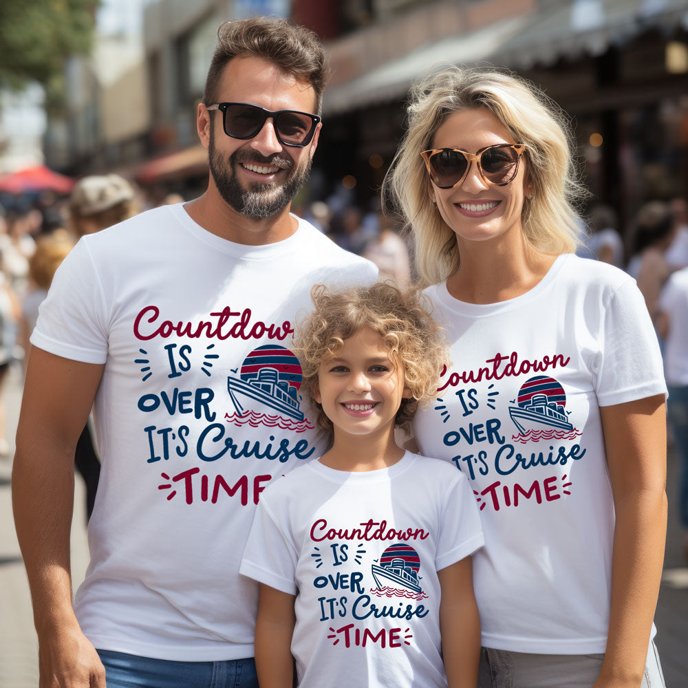 Family of three wearing matching 'Countdown is over, it's cruise time' t-shirts in an urban setting.