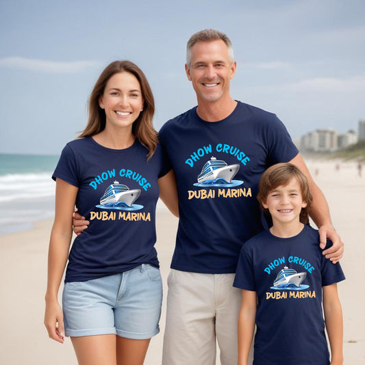 Family of three wearing navy blue t-shirts with Dhow Cruise Dubai Marina design on a beach.