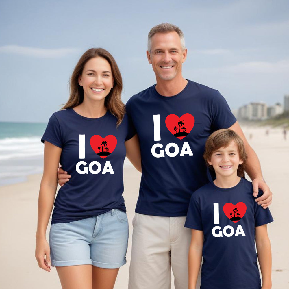 Family of three wearing 'I ❤️ Goa' t-shirts on a beach.