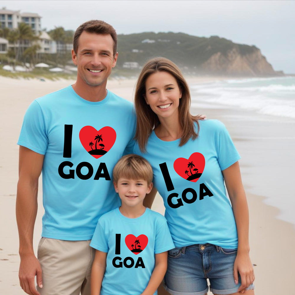 Family of three on a beach wearing 'I ❤️ Goa' t-shirts.