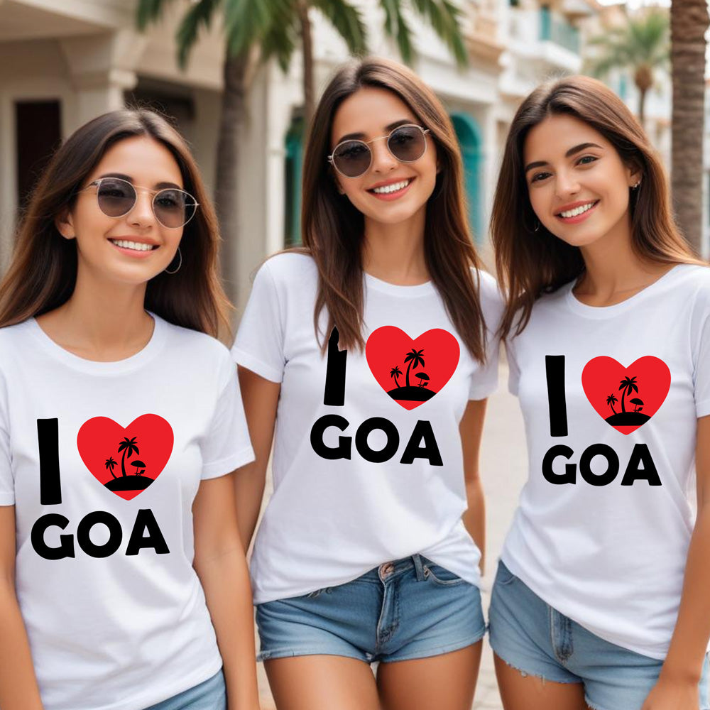 Three women wearing 'I ❤️ Goa' t-shirts on a street with palm trees.