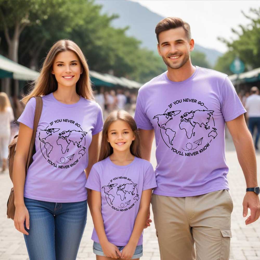 Family of three wearing matching purple t-shirts with a world map design outdoors.