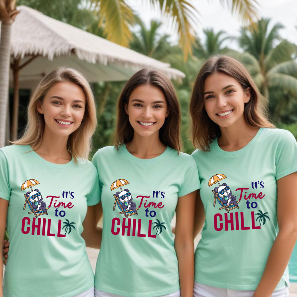 Three girls wearing green t-shirts with 'It's Time to Chill' design on a beach.