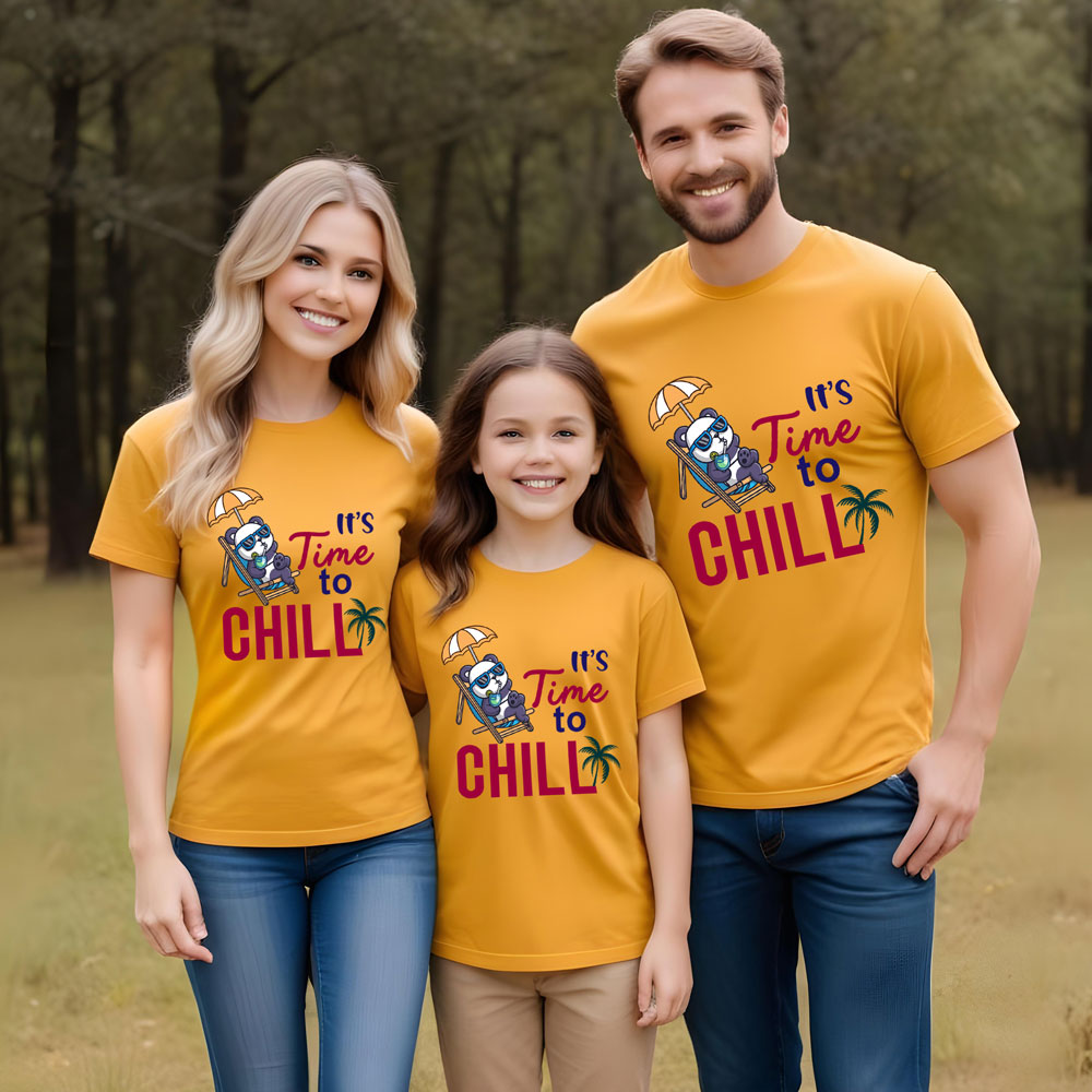 Family of three wearing matching yellow t-shirts with a graphic and text in a forest setting.