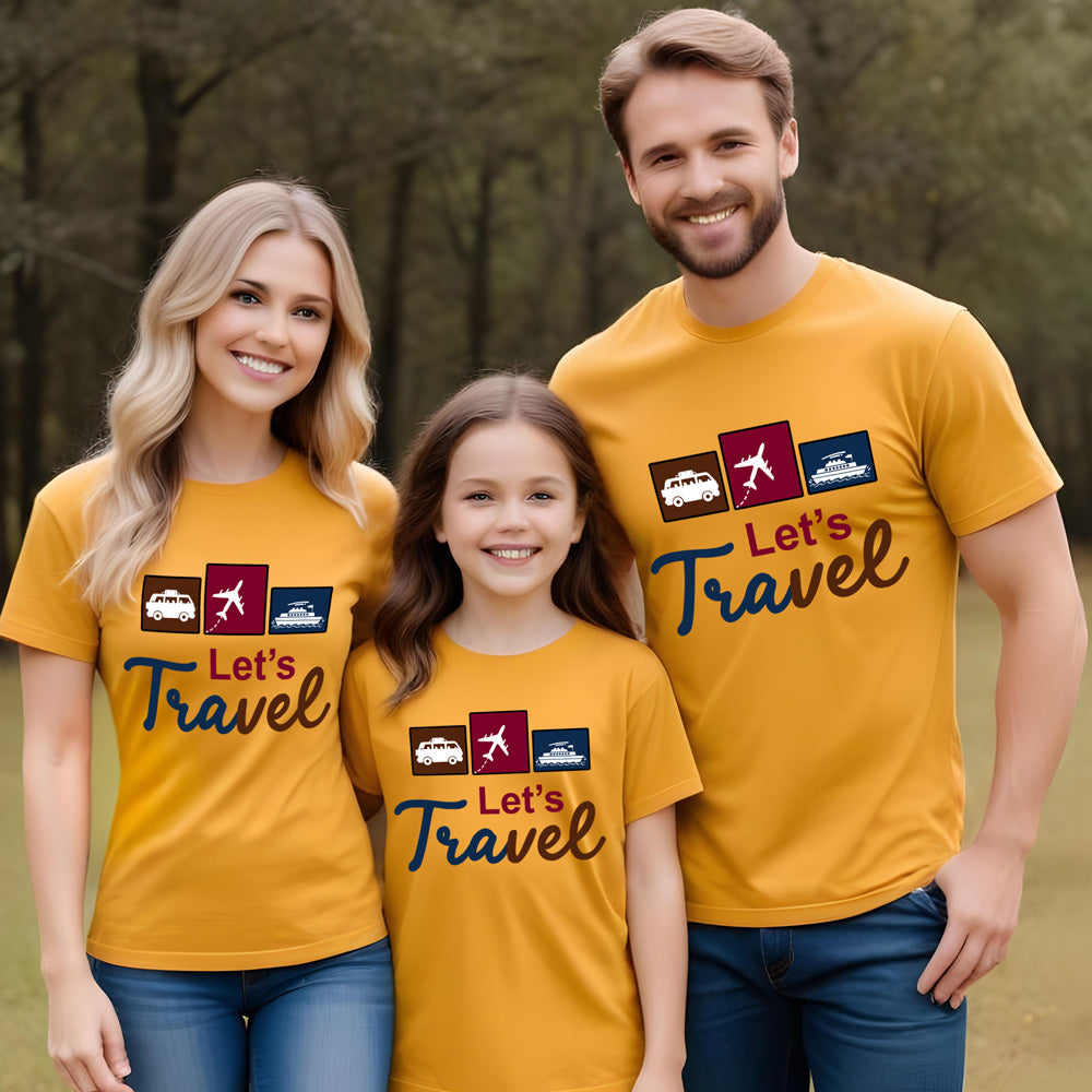 Family of three wearing matching yellow 'Let's Travel' t-shirts in a forest setting.