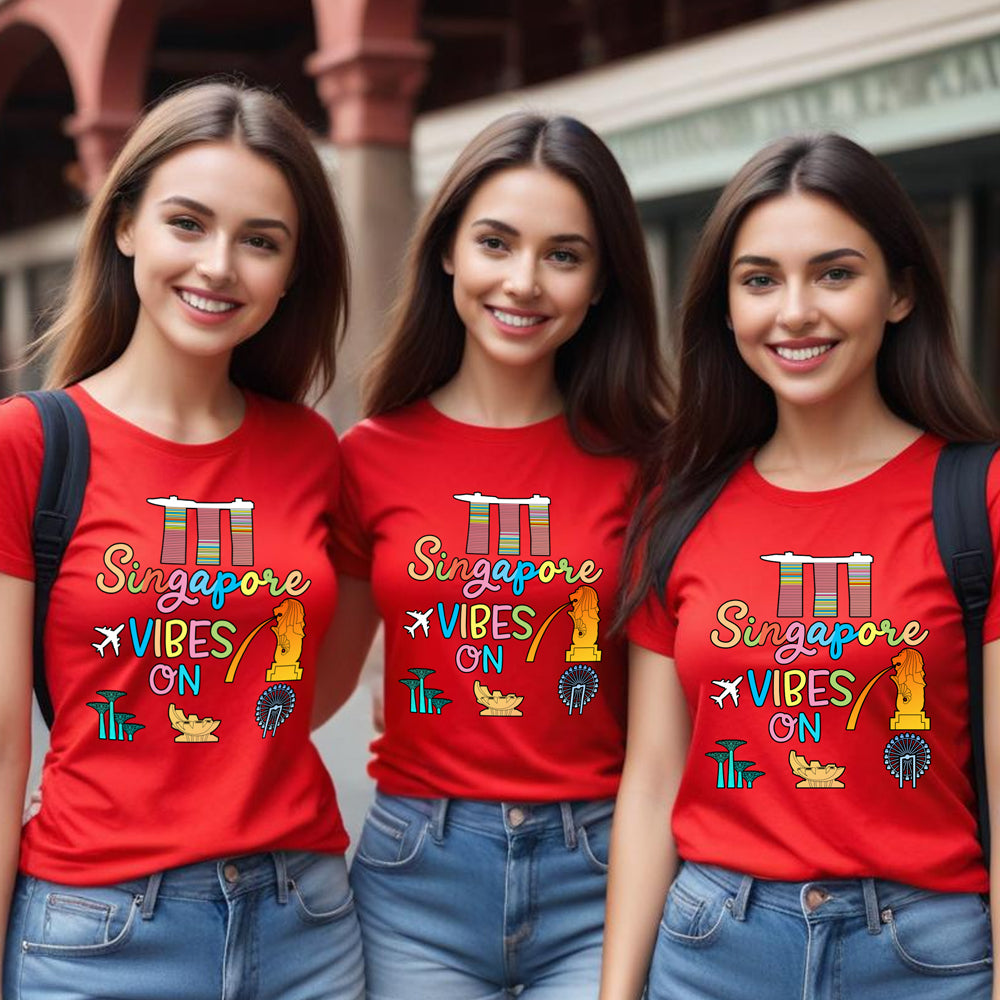 Three women wearing red t-shirts with 'Singapore Vibes On' design.