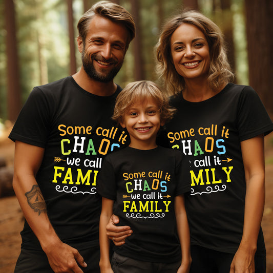 Family of three wearing black t-shirts with colorful text in a forest setting