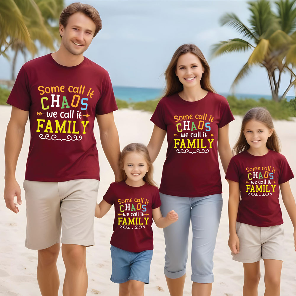 Family of four wearing matching maroon t-shirts with a family-themed design on a beach.