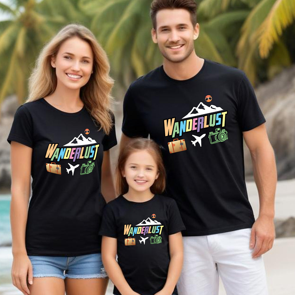 Family of three wearing black t-shirts with 'Wanderlust' design on a beach.