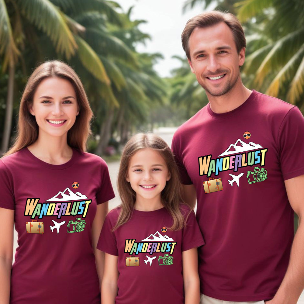 Family of three wearing maroon 'Wanderlust' t-shirts with a tropical background.