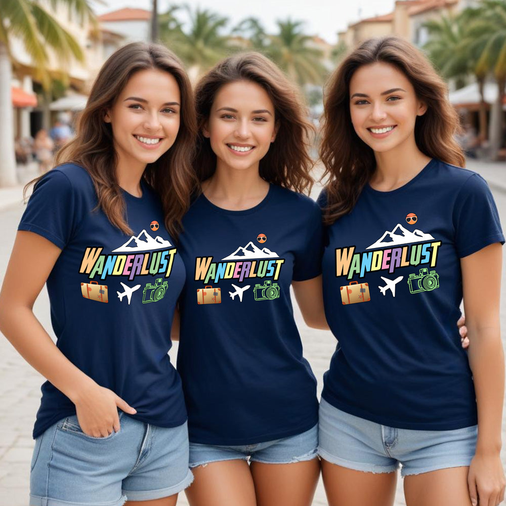 Three women wearing navy blue t-shirts with 'Wanderlust' design on a street background